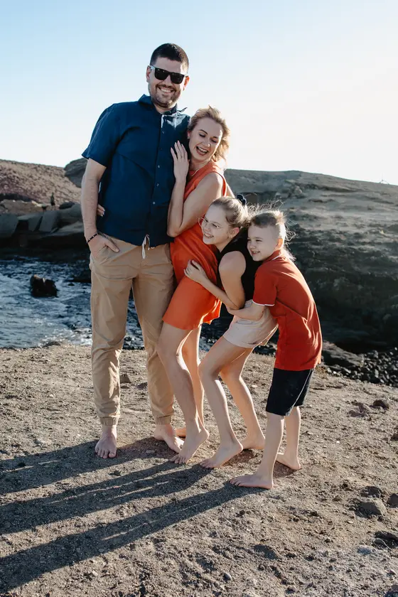Natural family session in Tenerife - parents with children playing on the beach
