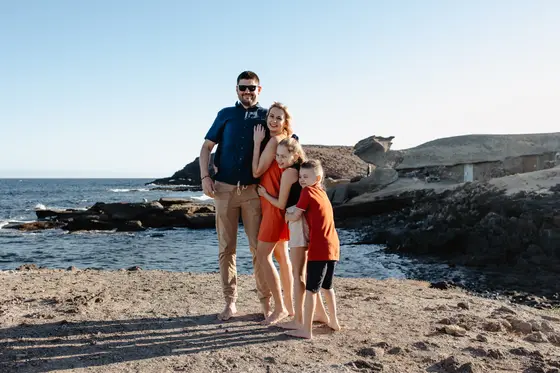 Tenerife family photography - family of four on rocky Abades beach at sunset
