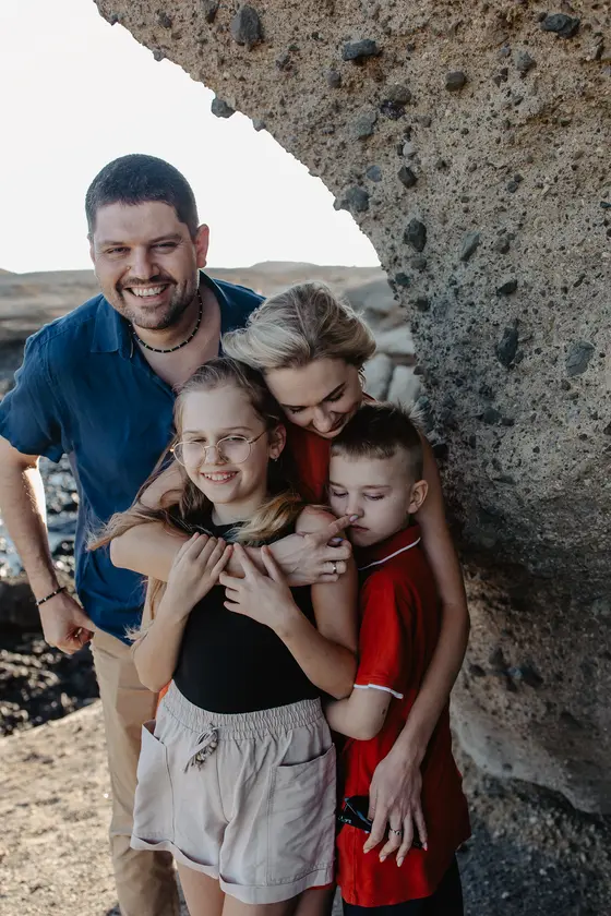 Intimate family session Tenerife - parents embracing children under volcanic arch