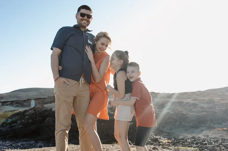 Sesión lifestyle en Tenerife - familia posando junto a rocas volcánicas en Abades