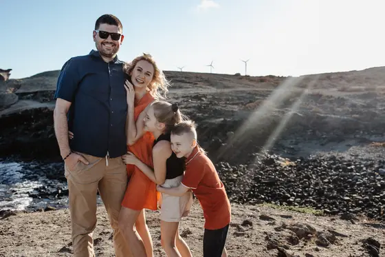 Family session with Tenerife windmills - parents with children against wind turbine backdrop