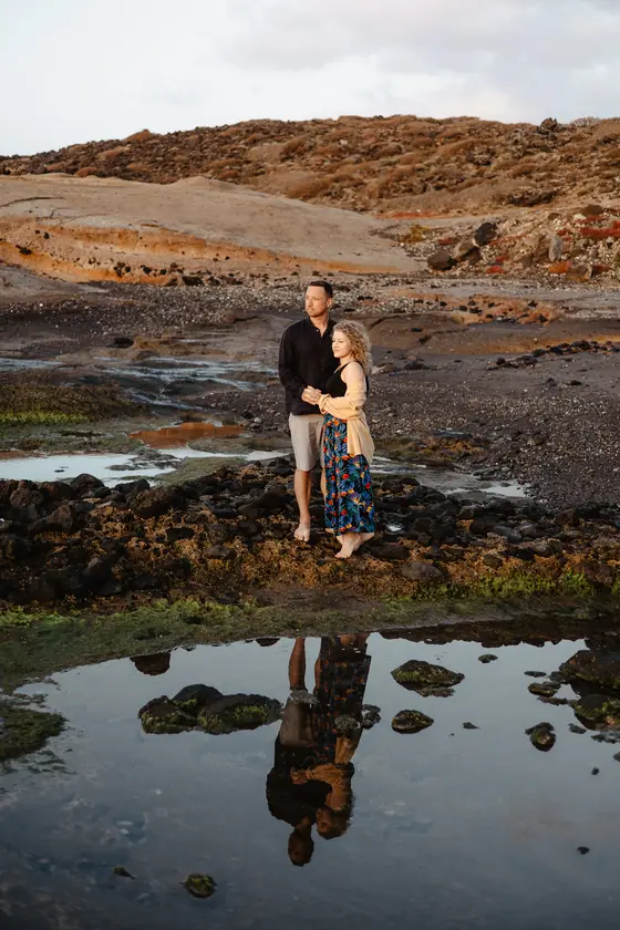 Couple reflection in natural tide pools during beach house photography Tenerife session