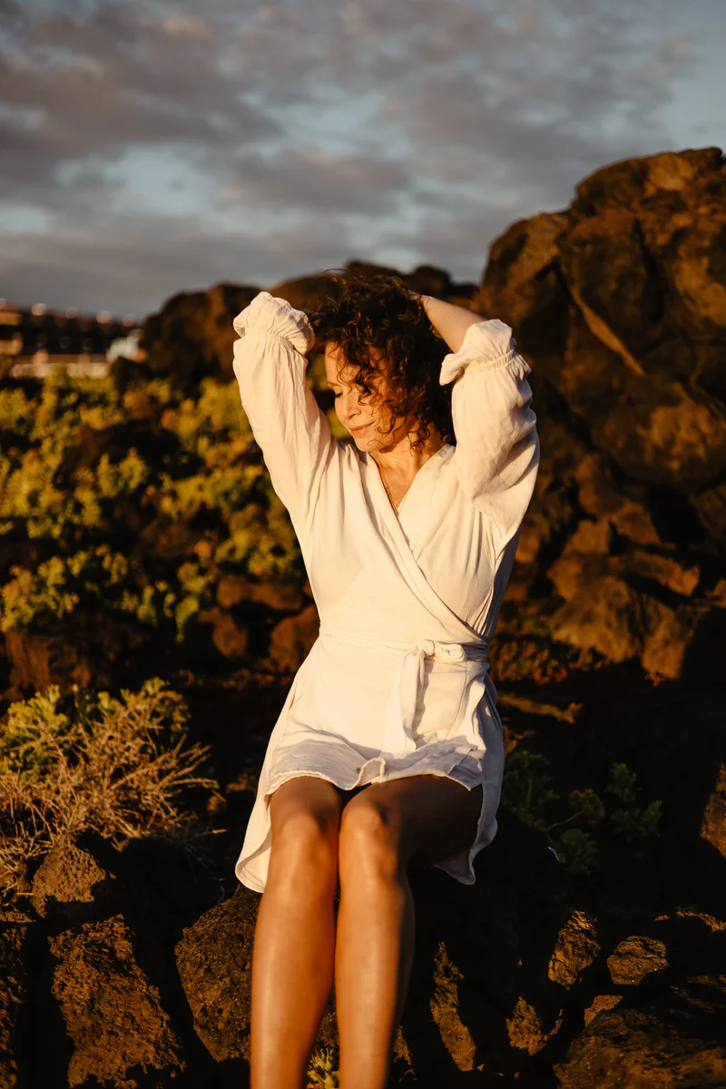 Monika Mrozowska en pose sensual entre rocas volcánicas de Tenerife durante la hora dorada