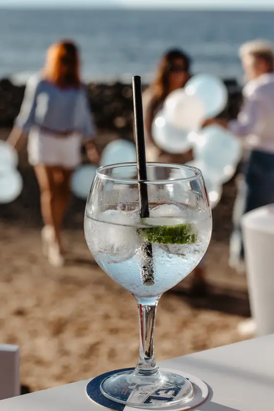 Elegant gin and tonic cocktail with lime on table in sunny event setting