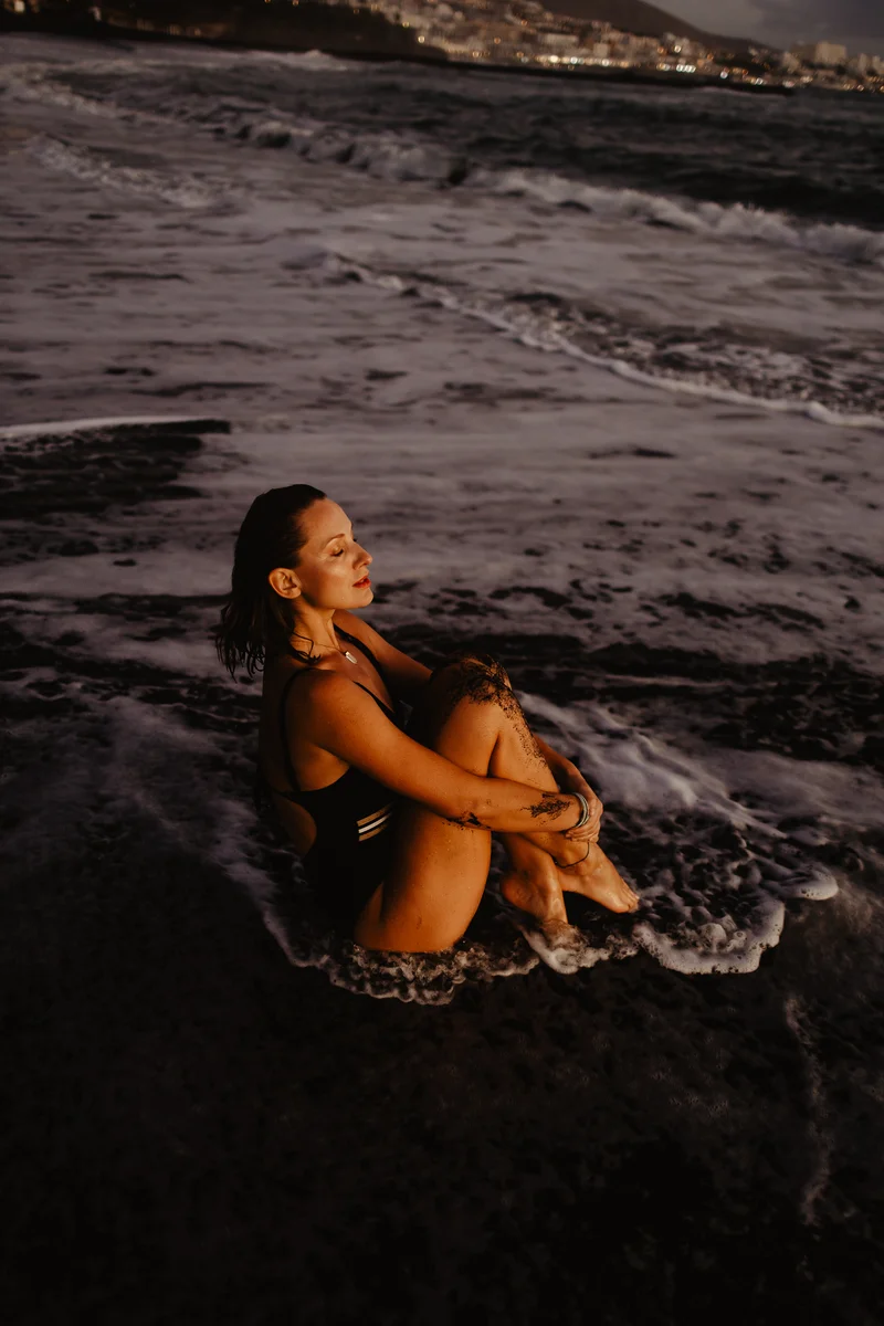 Joanna Moro feminine session by ocean shore with light reflections on water surface