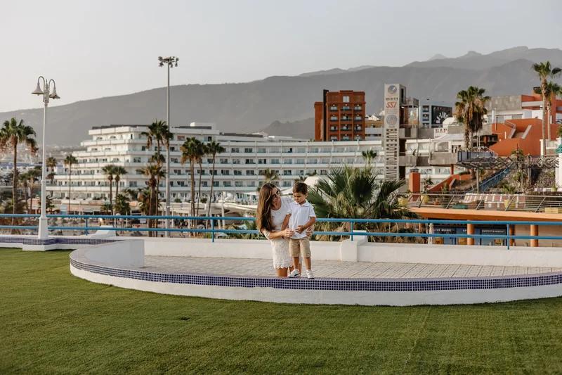 Couple on romantic walk in waterfront park in Tenerife with mountain views