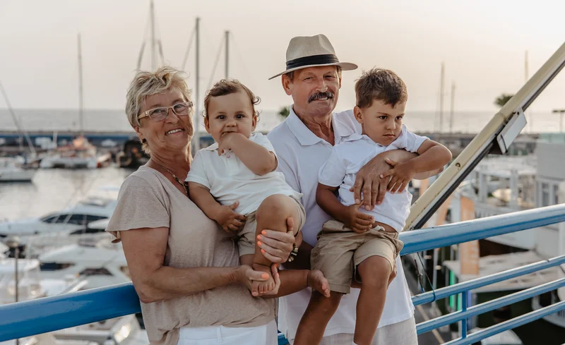 Grandparents with grandchildren at marina pier in Tenerife with boats background