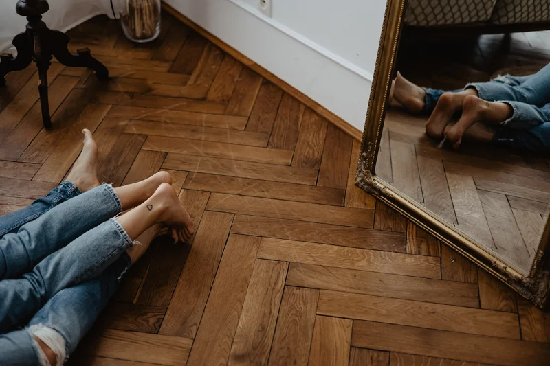 Feet reflection in mirror home photo session preparation Tenerife wooden floor setting