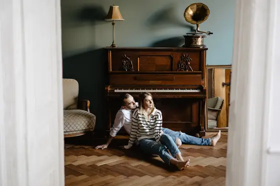 Couple sitting by piano preparing for home photo session preparation Tenerife lifestyle