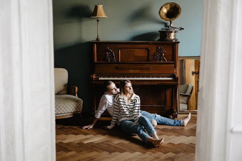 Couple sitting by piano preparing for home photo session preparation Tenerife lifestyle
