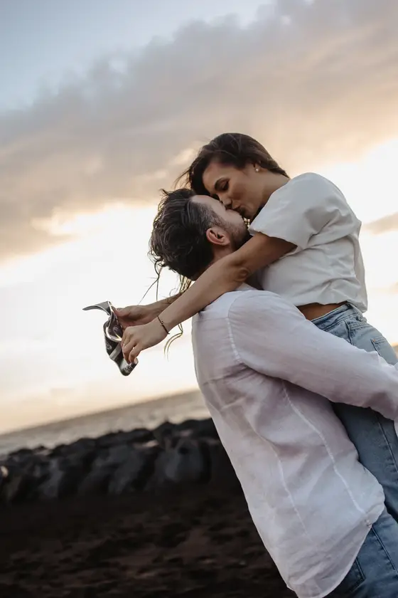 Intimate couple moment with natural eye contact against sunset backdrop