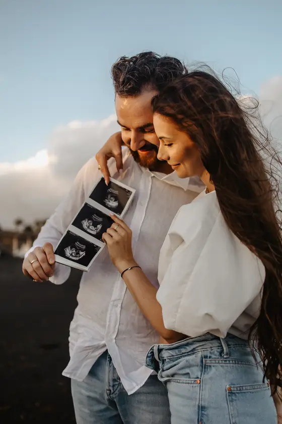 Spontaneous laughter of couple viewing ultrasound photos together in natural pose