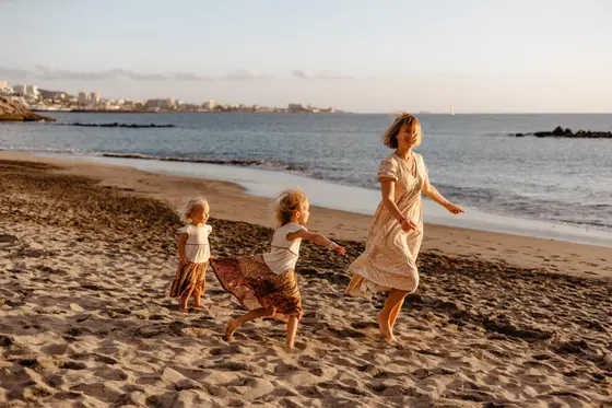 Sesión familiar en la playa con niños jugando junto al océano