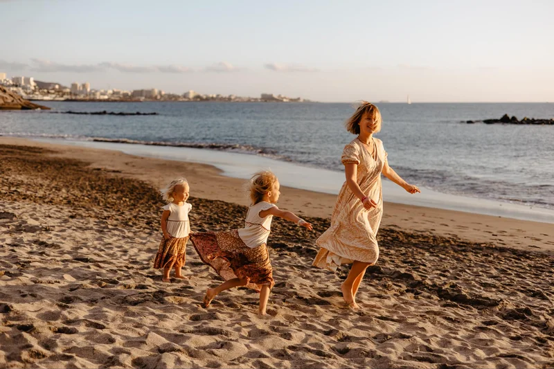Family beach session with children playing by the ocean