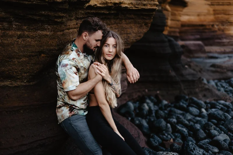 Couple sitting on ocean rocks during a natural session for two