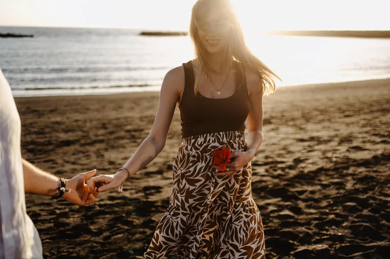 Pregnant woman walking by the ocean during a beach session