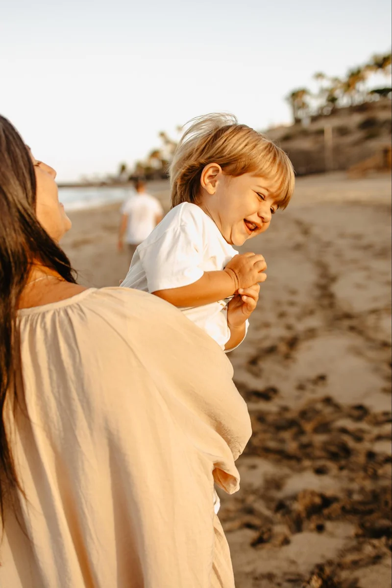 Child hugging mother during a family beach session