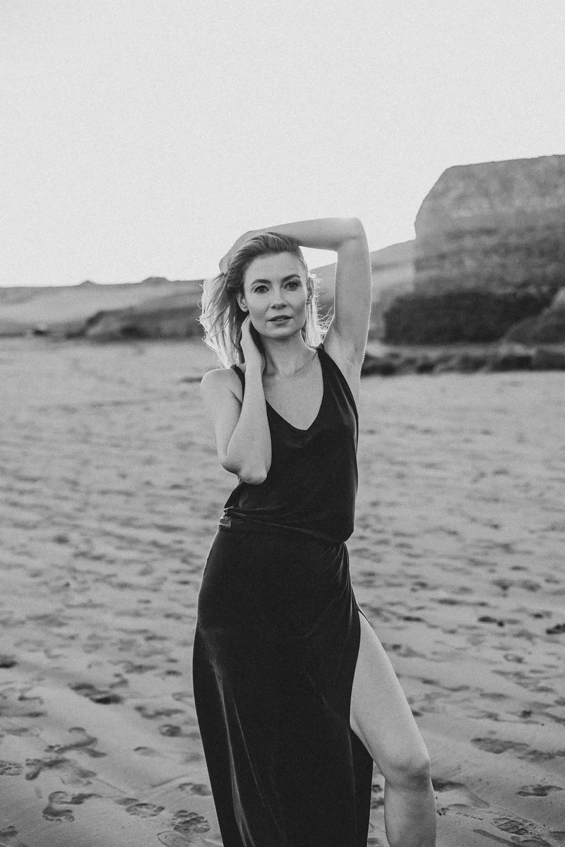 Karolina Chapko in black and white portrait on El Médano beach in elegant pose with hand in hair