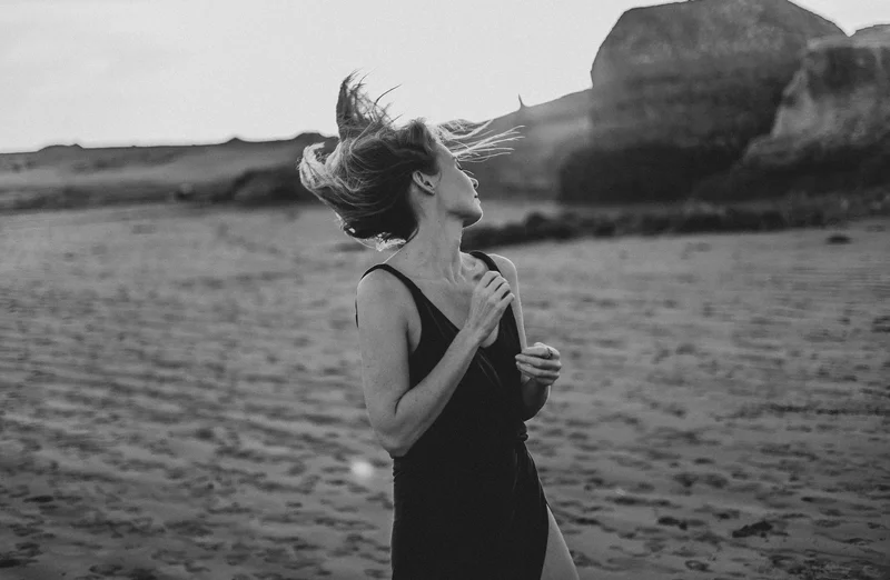 Black and white portrait of Karolina Chapko with flowing hair on windy El Médano beach in Tenerife