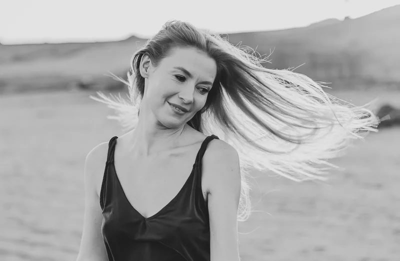 Black and white portrait of Karolina Chapko with naturally flowing hair against El Médano mountain landscape