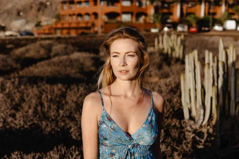 Retrato íntimo de Karolina Chapko con ojos cerrados contra el fondo de arquitectura hotelera de Tenerife