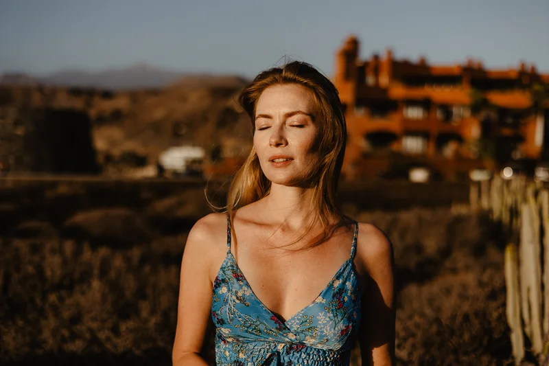 Retrato meditativo de Karolina Chapko con ojos cerrados bajo la cálida luz del atardecer de Tenerife