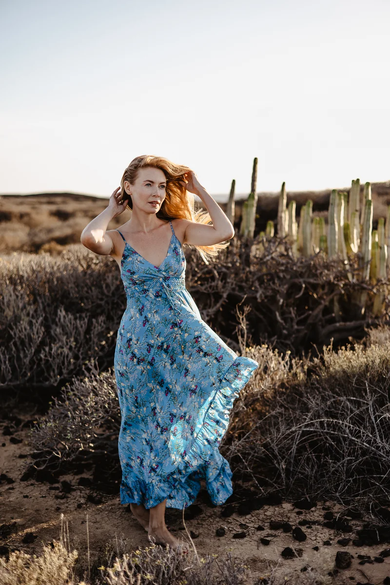 Retrato dinámico de Karolina Chapko con cabello al viento entre cactus en Tenerife durante la hora dorada