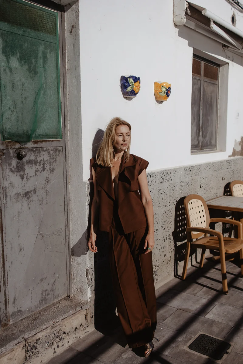 Sesión de moda con Karolina Chapko frente a casa canaria tradicional con contraventanas verdes en La Caleta