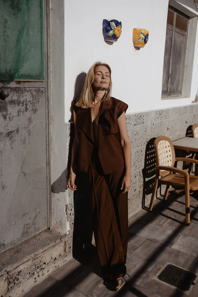 Retrato de Karolina Chapko con estilo marrón contra paredes blancas de arquitectura canaria