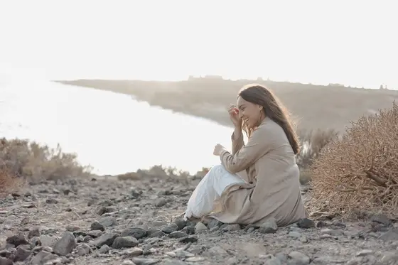 Mujer en pose natural en acantilados La Caleta con iluminación cálida del sol
