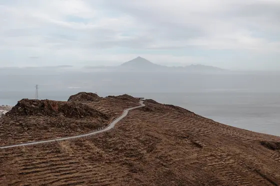 Serpentynowata droga przez wulkaniczny krajobraz La Gomera z widokiem na Tenerife w tle