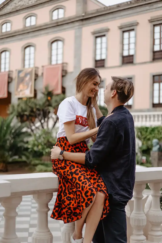Happy couple embracing against colonial La Orotava architecture backdrop during professional photoshoot in Tenerife