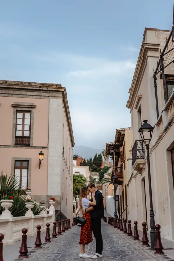 Romantic couple on cobblestone La Orotava street with traditional Canarian balconies and vintage streetlamps