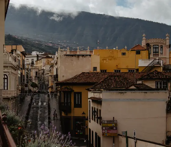 View of colorful colonial buildings and cobblestone streets in La Orotava Tenerife with mountains in background