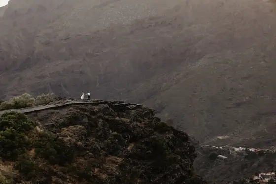 Masca wedding photography couple on rocky cliff edge with dramatic volcanic cliffs backdrop