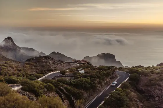 Masca wedding session serpentine mountain road through ravine with golden hour clouds