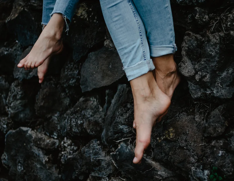 Artistic shot of feet on black volcanic rocks during Tenerife lifestyle photography session