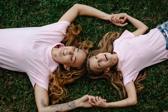 Mother and daughter lying on grass holding hands in lifestyle portrait session Tenerife photography