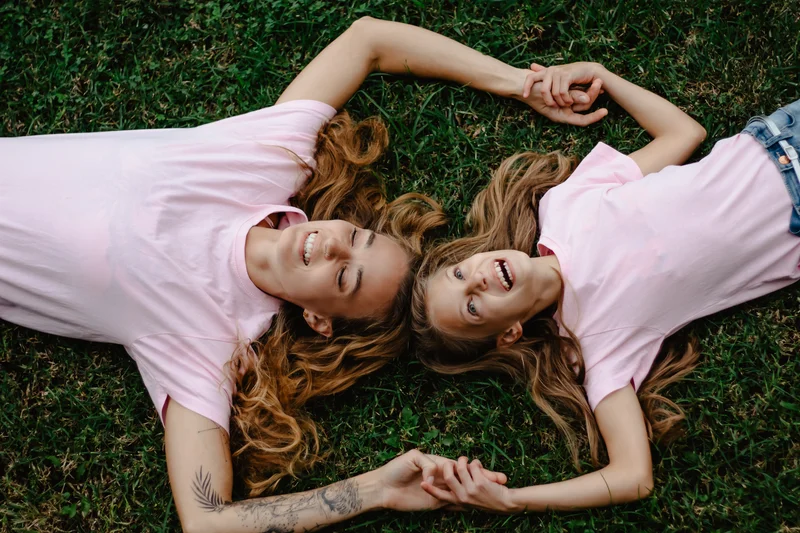 Mother and daughter lying on grass holding hands in lifestyle portrait session Tenerife photography