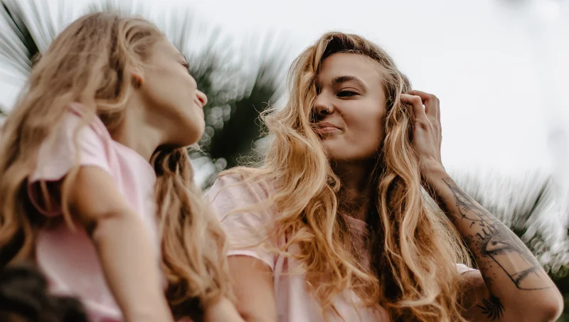 Mother and daughter in pink shirts posing among tropical vegetation in Tenerife lifestyle session