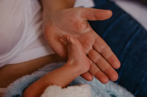 Mother's and newborn's hands connecting during intimate newborn photography Tenerife session