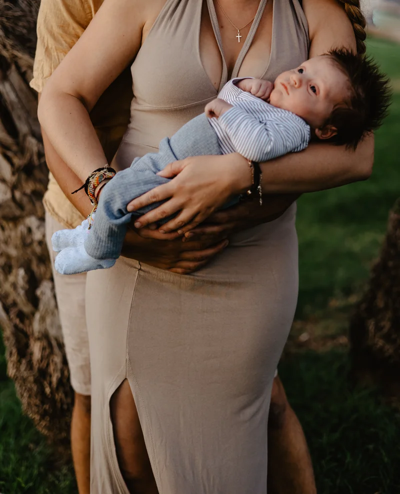 Mother holding newborn close to heart during intimate outdoor newborn photography session Tenerife