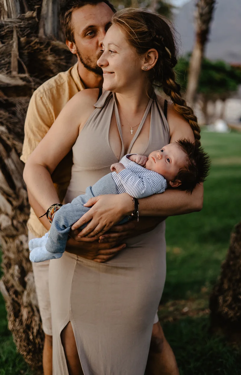 Tender moment of parents with newborn during outdoor newborn photography session Tenerife family closeness