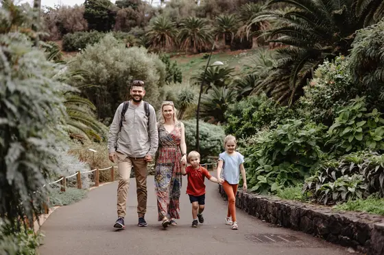 Familia tomada de la mano caminando por los senderos del Jardín Botánico Palmetum en Tenerife
