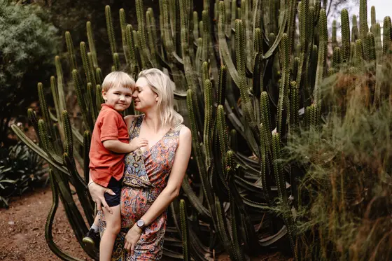 Tierna madre sosteniendo a su hijo entre cactus en el Jardín Botánico Palmetum en Tenerife