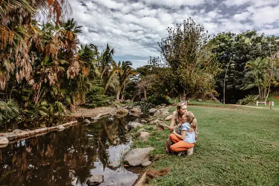 Madre con niño junto al estanque en el Jardín Botánico Palmetum en Santa Cruz de Tenerife