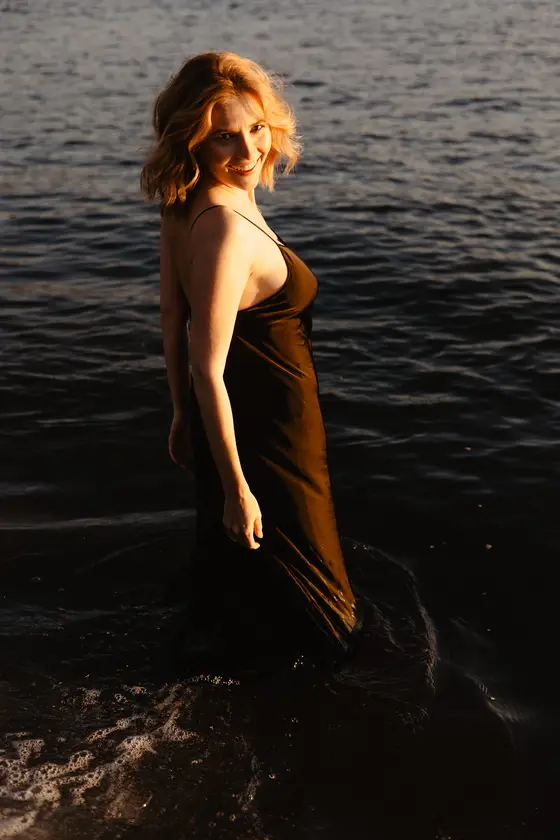 Smiling woman in ocean looking over shoulder during romantic photo session on Tenerife beach