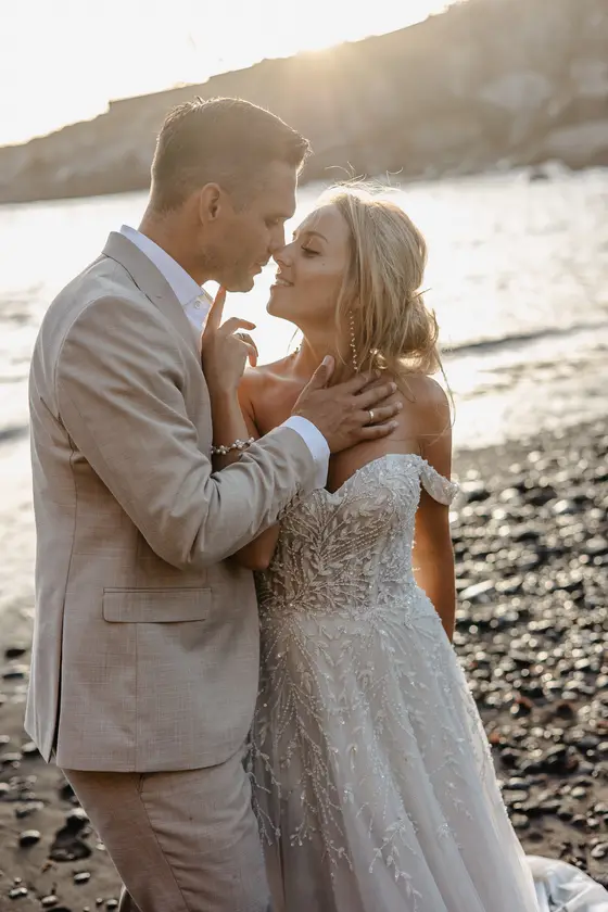 Wedding couple in tender moment of closeness in golden sunset light on Playa Paraiso coastline
