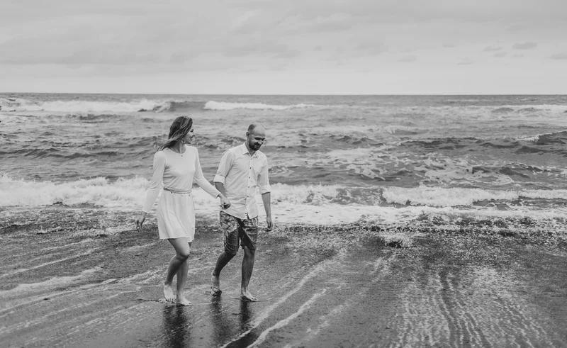 Artystyczne czarno-białe zdjęcie pary na mokrej plaży Puerto de la Cruz