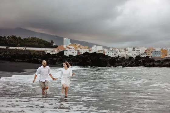 Couple running hand in hand on beach in Puerto de la Cruz Tenerife